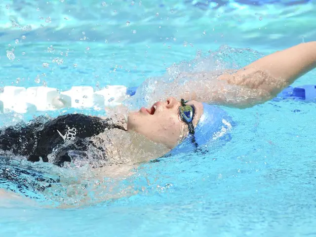 In this image there is a swimming pool, in that swimming pool there is one woman who is wearing...