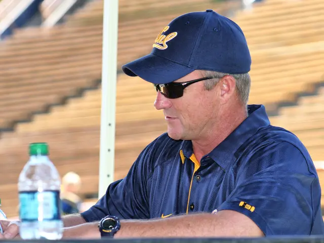 This is the picture of a person who is in blue color tee shirt wearing a hat and the shades holding...