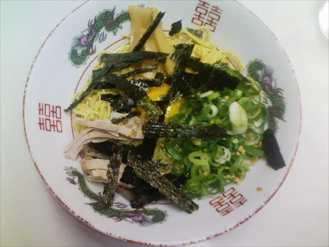 In the image there is veg salad,noodles,flour sticks in white plate on a table.