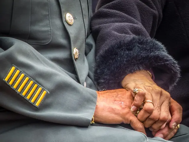 This is a zoomed in picture. On the left there is a person seems to be sitting on the chair. On the...