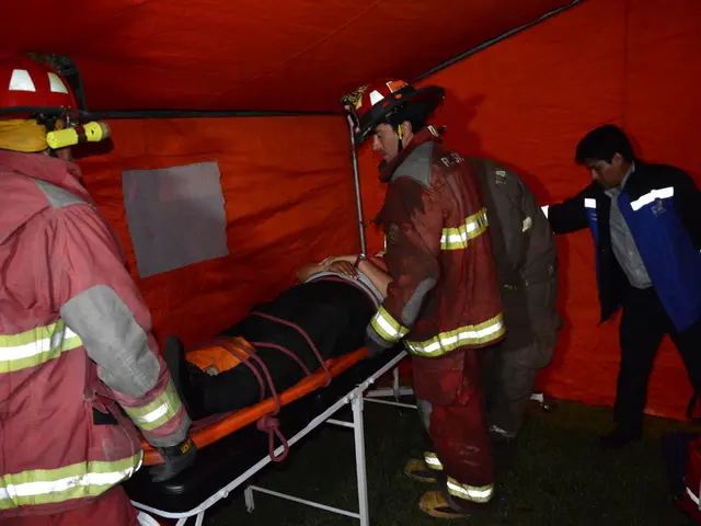 In the foreground of this image, there is a tent. Under it, there is a man on the stretcher and...