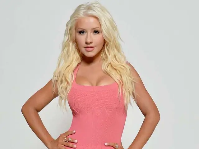 In the picture we can see a woman standing and keeping her hands on her hip and she is wearing a...