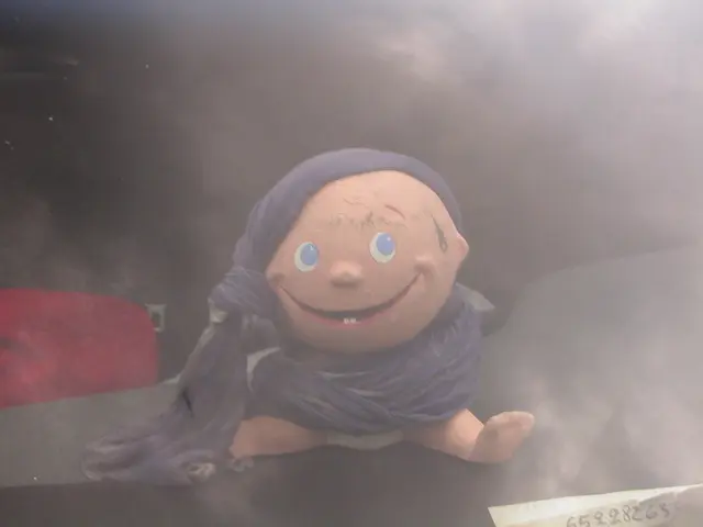 In the image there is a baby toy with cloth wrapped around sitting on a table.