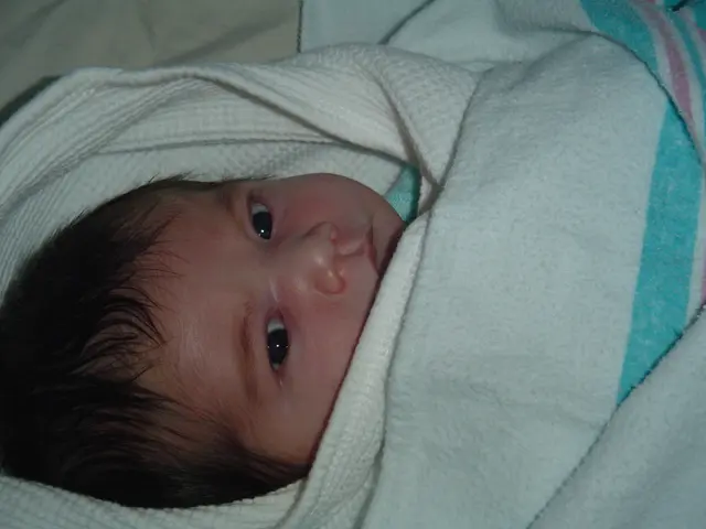 In this image we can see a child wrapped in a blanket.